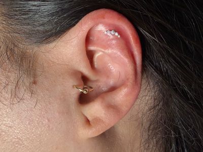 Flat piercing with 14k Yellow Gold Cluster/Multi-Gem by Buddha Jewelry by Mingo at Platinum Tattoos & Piercings, San Antonio TX