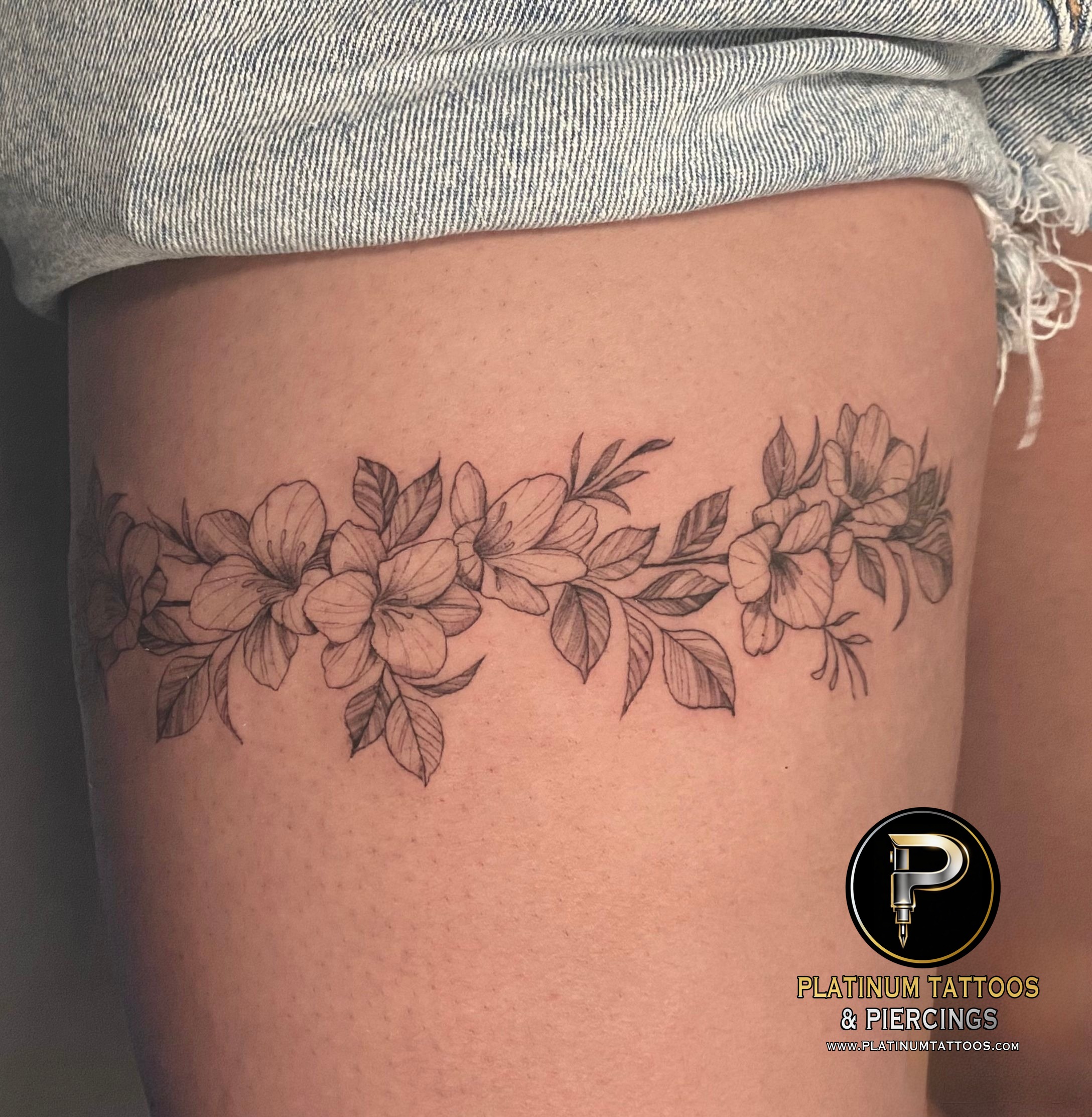 Floral tattoo on the thigh by Remy at Platinum Tattoos & Piercings, San Antonio TX