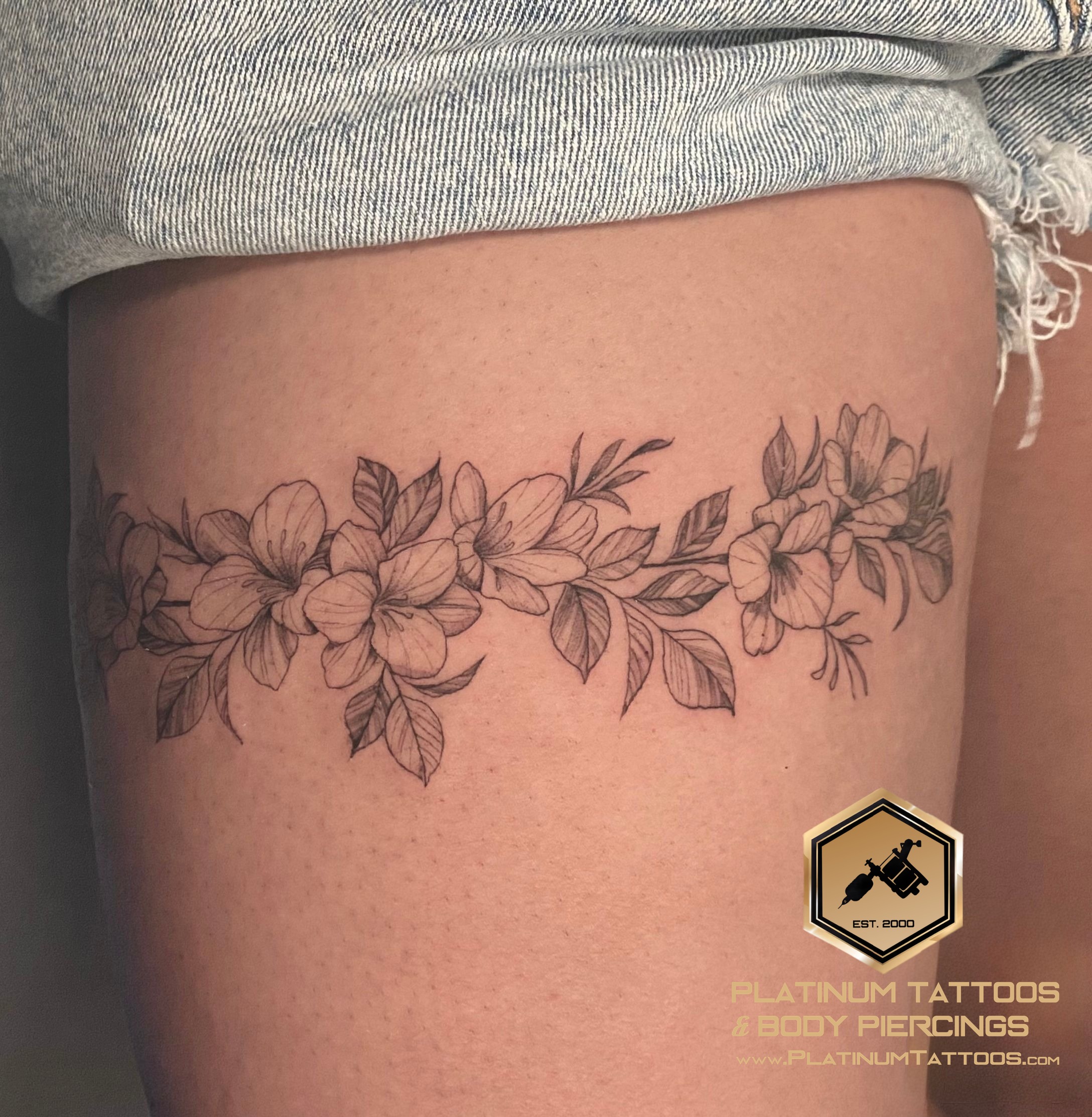 Floral tattoo on the thigh by Remy at Platinum Tattoos & Piercings, San Antonio TX