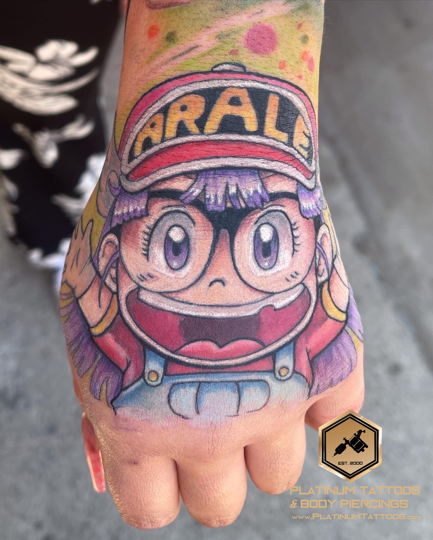 Arale Norimaki Dr. Slump anime tattoo on the hand by Jerson at Platinum Tattoos & Piercings, San Antonio TX