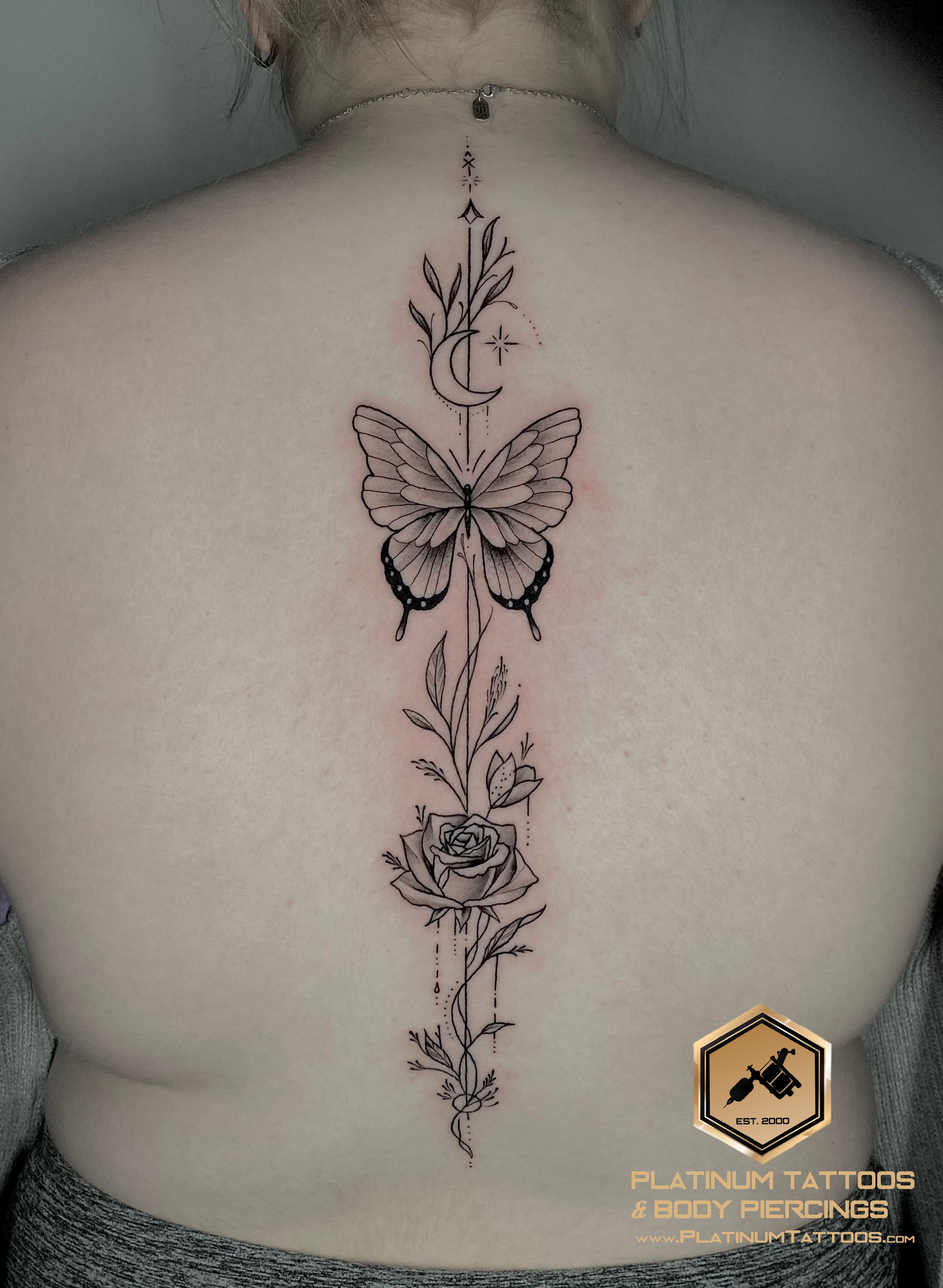 Fine Line Black Butterfly, Flower tattoo on the Spine by Remy at Platinum Tattoos & Piercings, San Antonio TX