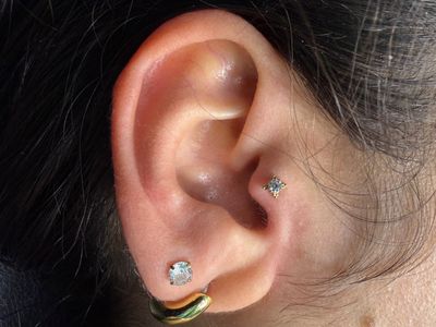 Tragus piercing with 18k Yellow Gold Labret Stud/Flat Back by Anatometal by Mingo at Platinum Tattoos & Piercings, San Antonio TX