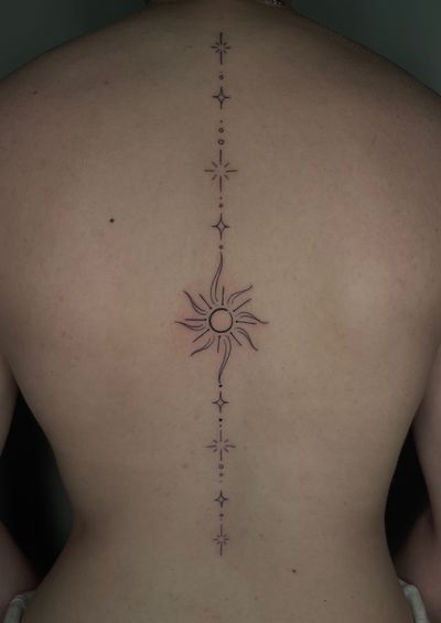 Fine Line Black Sun tattoo on the Spine by Remy at Platinum Tattoos & Body Piercings, San Antonio TX
