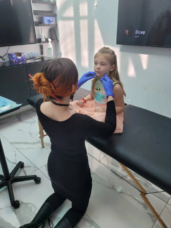 Piercer working with young girl on ear piercing at Platinum Body Piercings San Antonio